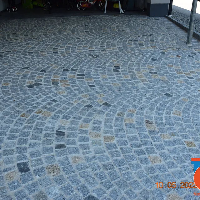 Exklusive Hauseinfahrt aus hellgrauem Granit Kleinpflaster mit dunkelgrauen und gelben Granitwürfeln in Katsdorf