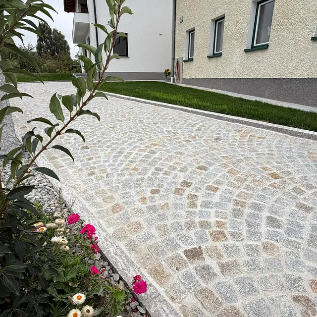 Hauseinfahrt aus gelbgrauem Granit Kleinsteinpflaster im Segmentbogenverband in Rainbach im Mühlkreis, Bezirk Freistadt
